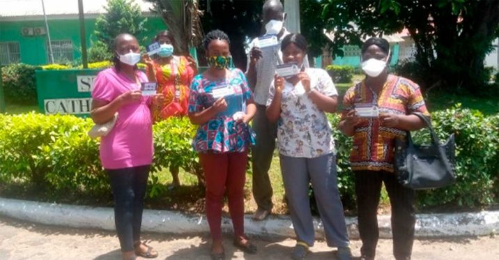 More staff members with their vaccination card.