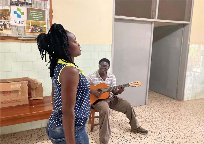 Una paciente canta y baila con el acompañamiento a la guitarra del terapeuta