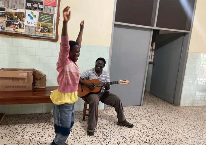 Una paciente canta y baila con el acompañamiento a la guitarra del terapeuta