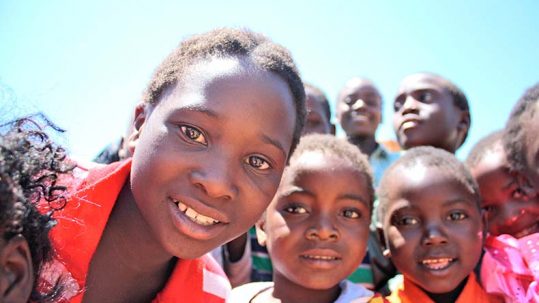 Varios niós y niñas africanos sonríen a la cámara
