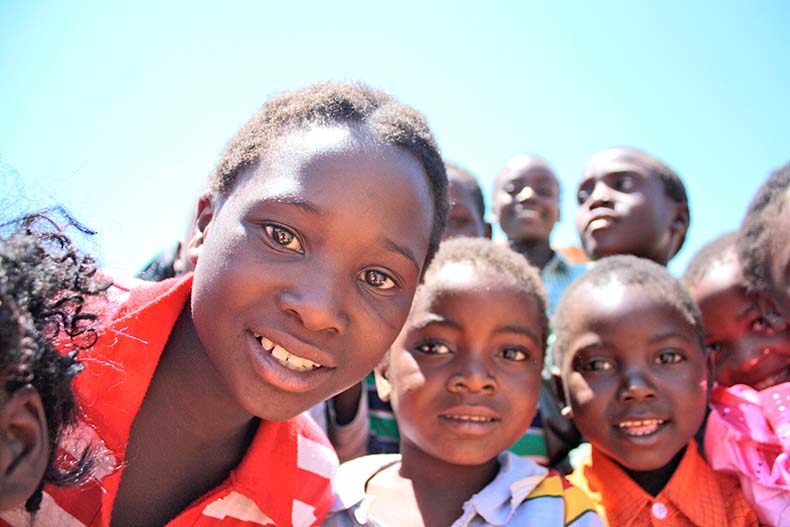 Varios niós y niñas africanos sonríen a la cámara